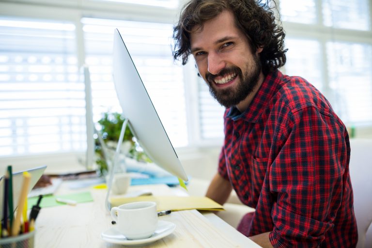 Office worker smiles while working on a computer