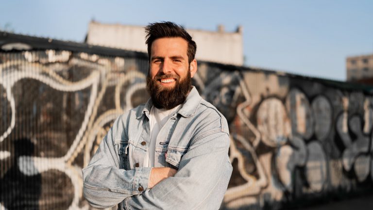 Creator Dan Pulzello, TikTok’s European Boss. He wears a jeans jacket and smiles at the camera.