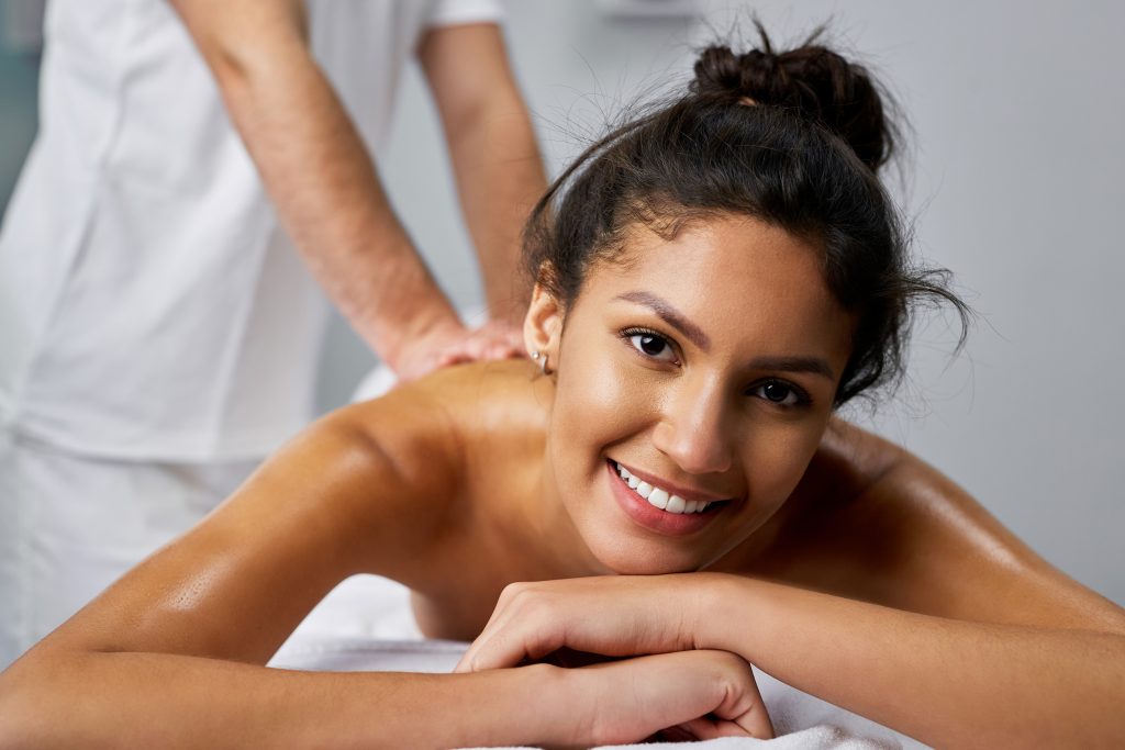 Young woman having a back massage while spending a day at a spa